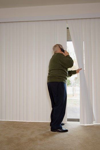 Elderly man on phone and looking out of window