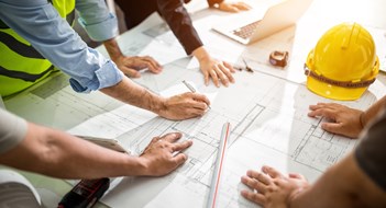Managing Major Construction Projects Team Engineer drawing graphic planning of interior creation project cooperating with talented teacher giving advice, working concept.